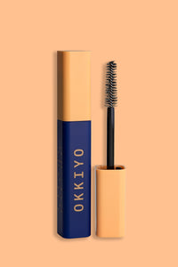 PRODUCT IMAGE OF PRIORITEYES MASCARA BY OKKIYO.  THE TUBE IS NAVY BLUE AND SQUARE.  THE LID IS APRICOT.  LOGO SAYS OKKIYO IN BOTH BRAILLE AND TEXT.